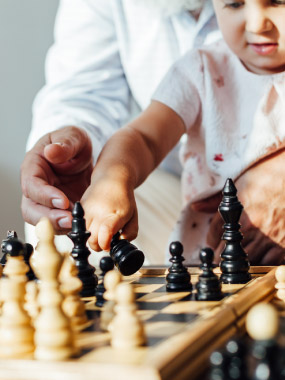 A baby and grandfather playing chess