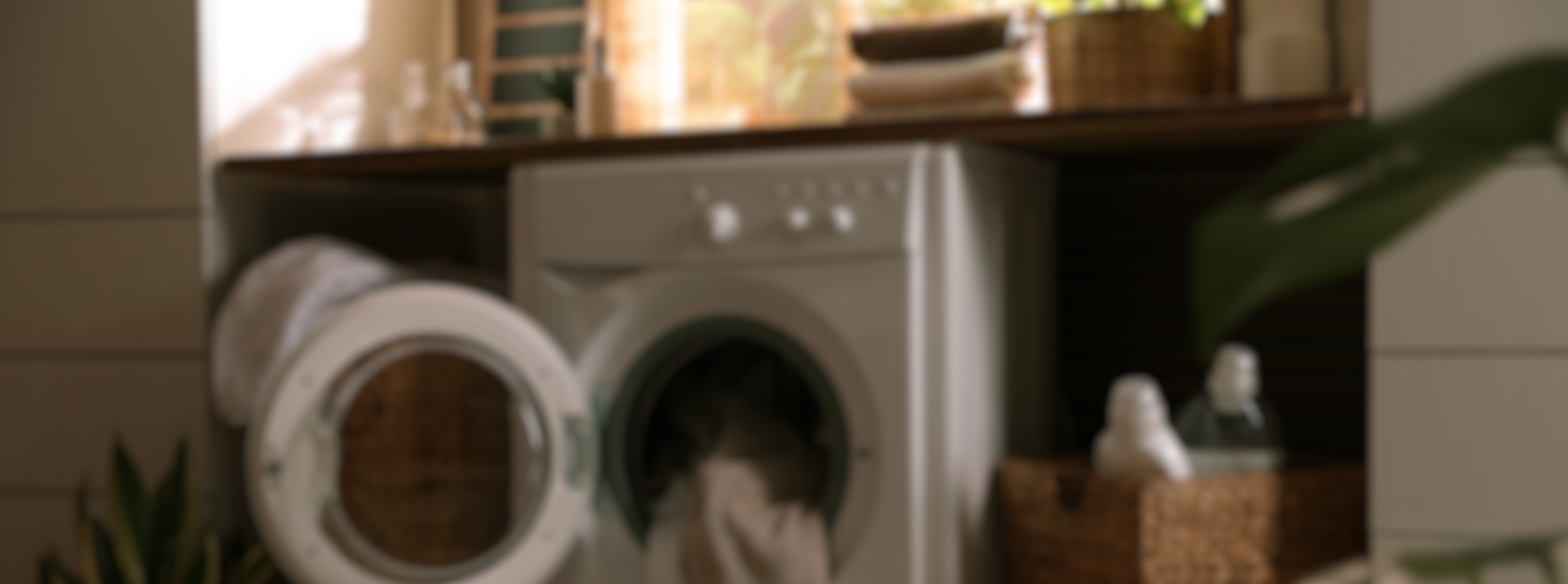 open washing machine with a towel hanging out of it 