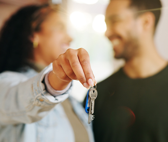 A couple holding a set of house keys.