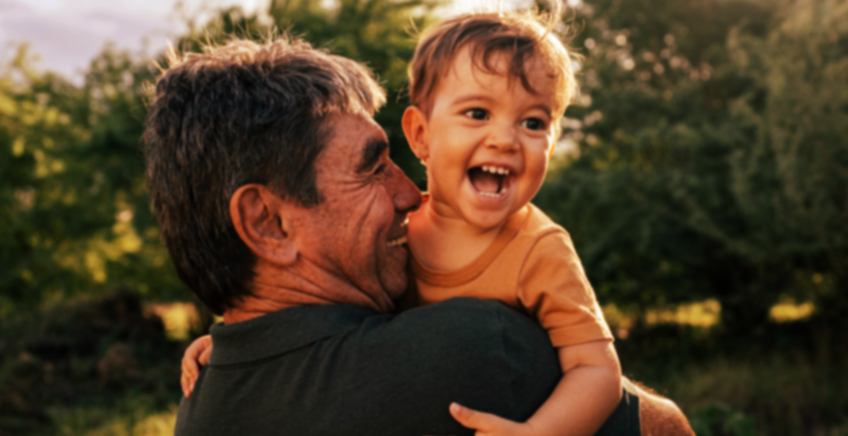 grandfather holding grandson smiling