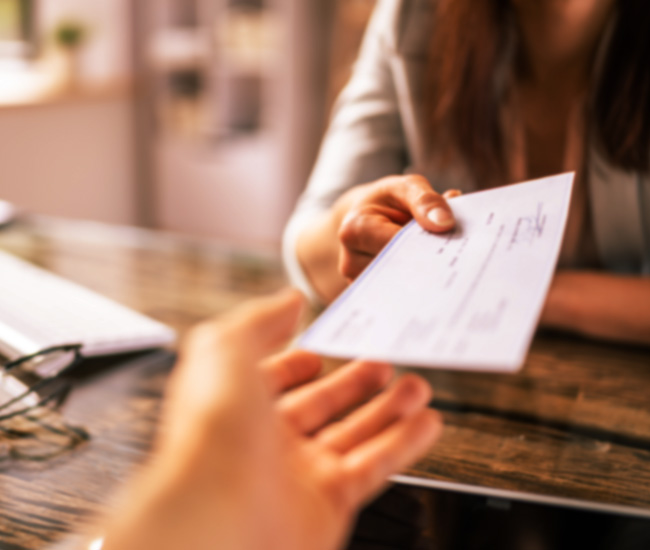 lender handing a customer a bank check